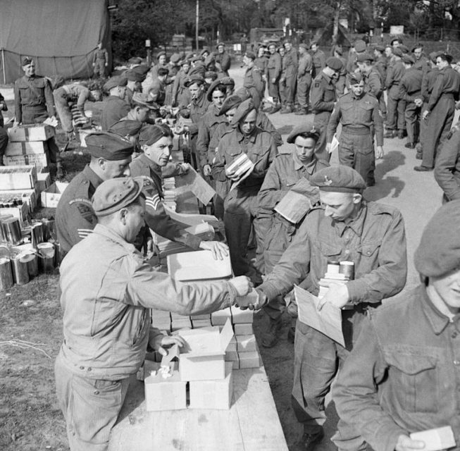 The Green Howards receive 48-hour ration packs before embarking onto landing ships during Exercise ‘Fabius’, 5 May 1944.