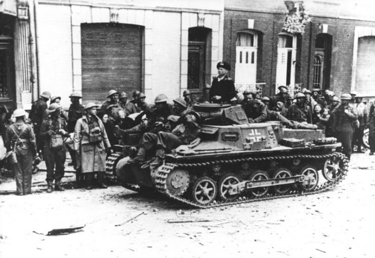 British prisoners of war with a Pz.Kpfw Ib German tank in Calais in May 1940. By Bundesarchiv – CC BY-SA 3.0 de