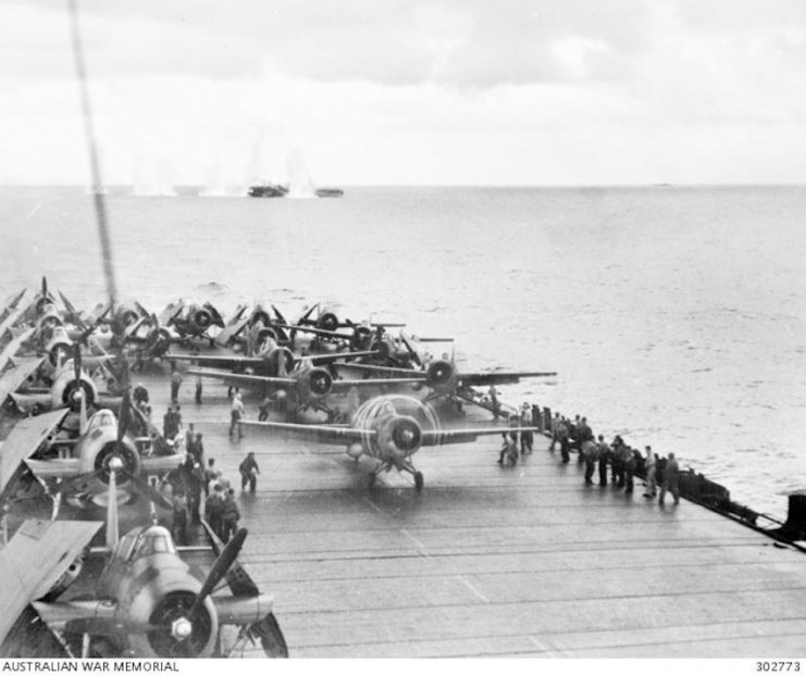 The US escort carrier USS Kitkun Bay prepares to launch Grumman FM-2 Wildcat fighters during the Battle of Samar on 25 October 1944. Incredibly in the distance, Japanese shells are splashing near the USS White Plains.