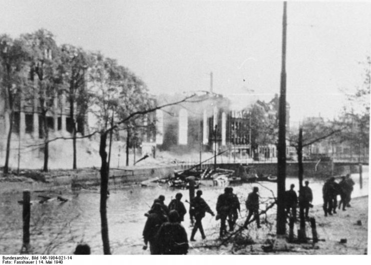 German troops advance through a destroyed section of Rotterdam.