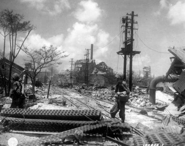 GIs at the wreckage of a Japanese sugar mill in Saipan.