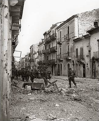Infantrymen of the Loyal Edmonton Regiment advance with Sherman tanks of the Three Rivers Regiment during the Battle for Ortona.