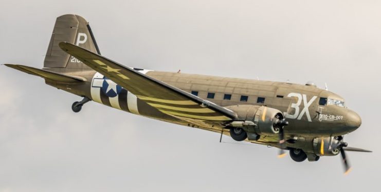 East Kirkby, UK – August 6, 2016: a Douglas C-47 Skytrain / Dakota military transport aircraft of WWII pictured in flight over Lincolnshire, England.