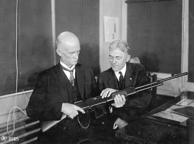John M. Browning, the inventor of the gun, and Mr. Burton, the Winchester expert on rifles, discussing the finer points of the Browning Light Gun (BAR) at the Winchester Plant.