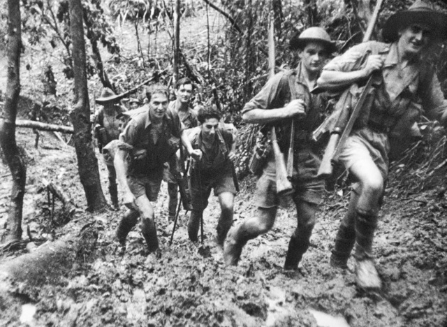 Kokoda retreat.Some members of D Company, 39th Battalion, returning to their base camp after a battle at Isurava.Their shoes sink deep in the mud on the hilly jungle track.
