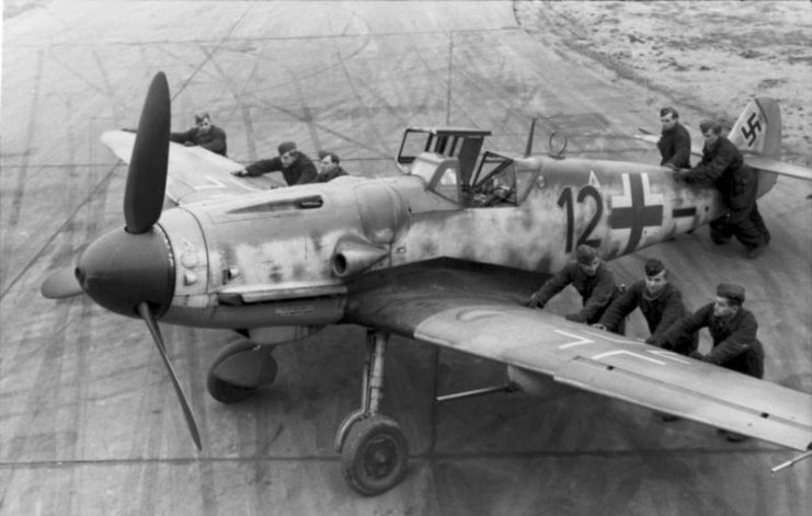 Luftwaffe ground-crew positioning a Bf 109G-6 equipped with the Rüstsatz VI underwing gondola cannon kit. France, late 1943. Bundesarchiv, Bild 101I-487-3066-04 Boyer CC-BY-SA 3.0