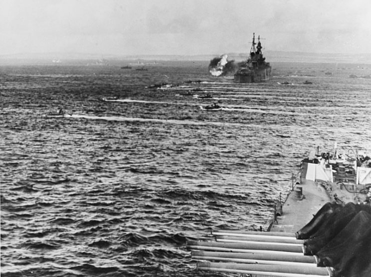 LVTs heading for shore on June 15, 1944. The Birmingham is in the foreground; the cruiser firing in the distance is the Indianapolis.