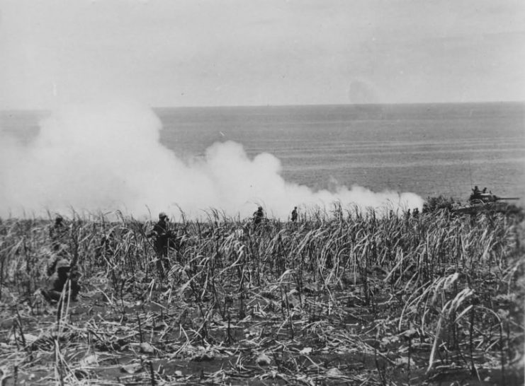 Marines following an advancing Sherman M4 Tank in Saipan, 1944.