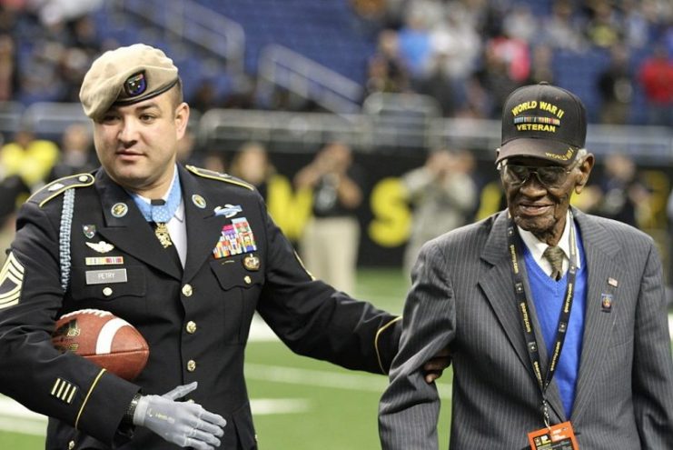 Medal of Honor recipient retired Master Sgt. Leroy Petry walks the field of the Alamodome with World War II veteran Richard Overton in San Antonio, Jan. 3, 2015.
