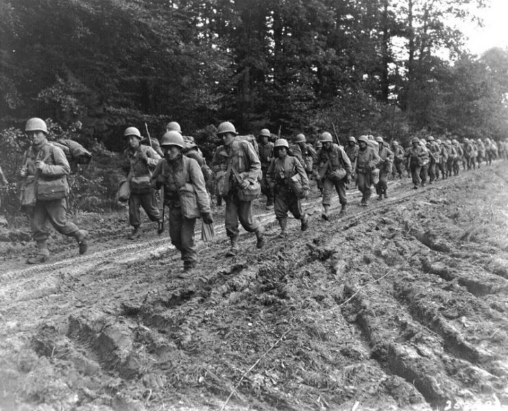 The 442nd Regimental Combat Team hiking up a muddy road in the Chambois Sector, France, in late 1944