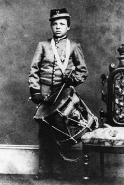 Young boy wearing Union Army uniform holds drum, circa 1861
