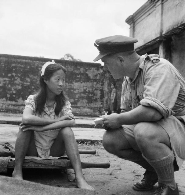 A Chinese girl from one of the Japanese Army’s ‘comfort battalions’ sits on a stretcher, awaiting interrogation at a camp in Rangoon.