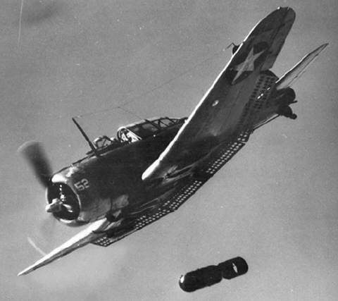A U.S. Navy SBD releasing a bomb. Note the extended dive brakes on the trailing edges.