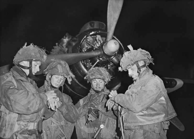 British Pathfinders synchronize their watches in front of an Armstrong Whitworth Albemarle.