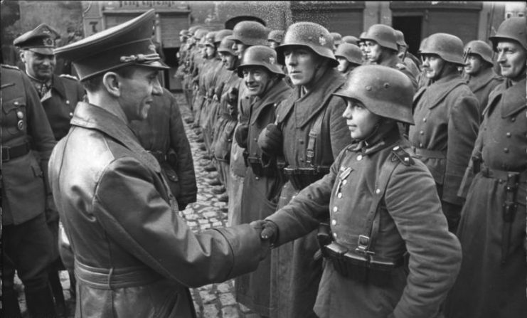 March 9, 1945: Goebbels awards a 16-year-old Hitler Youth member, Willi Hübner, the Iron Cross for the defense of Lauban. Photo: Bundesarchiv, Bild 183-J31305 / CC-BY-SA 3.0