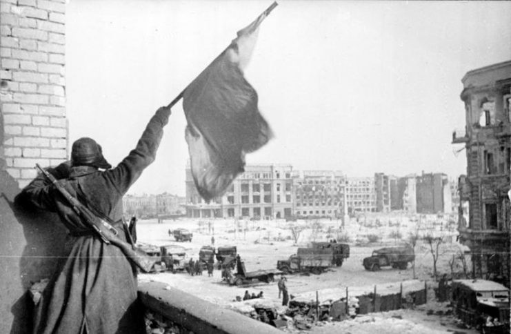 A Soviet soldier waving the Red Banner over the central plaza of Stalingrad. Photo: Bundesarchiv, Bild 183-W0506-316/Georgii Zelma/CC-BY-SA 3.0