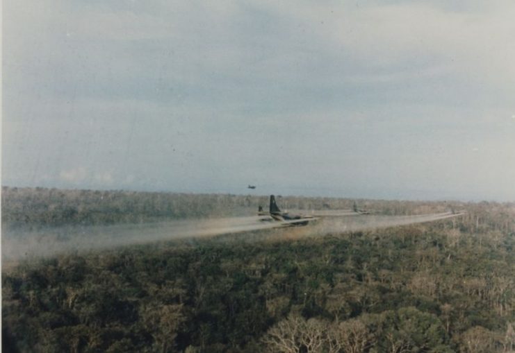 Group of U.S military C-123 aircraft spraying Agent Orange over Vietnamese jungle.