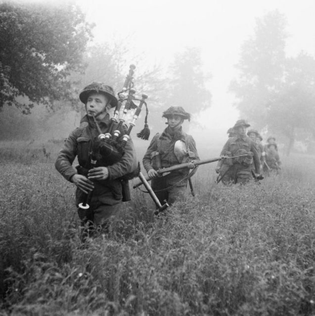 Led by their piper, men of the 7th Seaforth Highlanders, 15th (Scottish) Division advance during Operation Epsom, 26 June 1944.