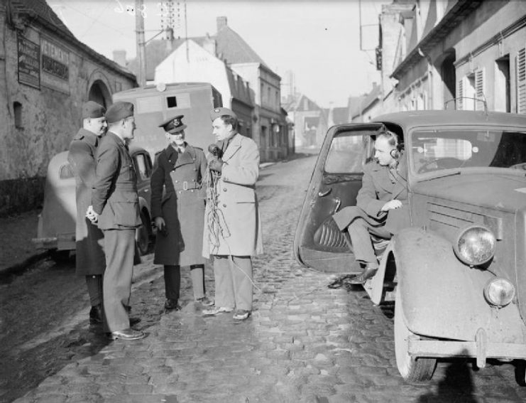 Royal Air Force- France, 1939-1940. Charles Gardner, the BBC war reporter, and his sound engineer E L Lysett (sat in the car at right), recording an interview with RAF officers outside their billets in a town in northern France.