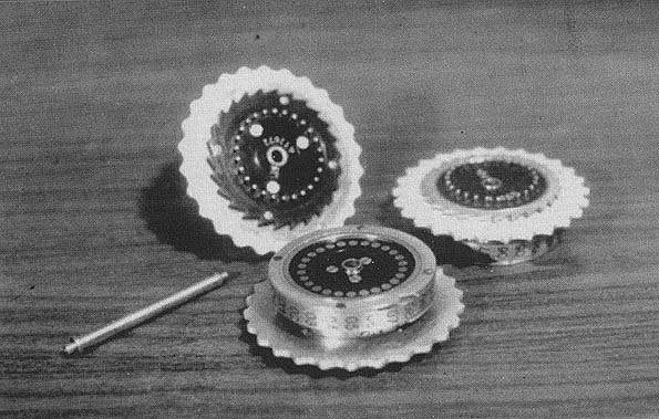 Three Enigma rotors and the shaft on which they are placed when in use.
