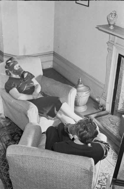 A British couple wearing gas masks in their home in 1941