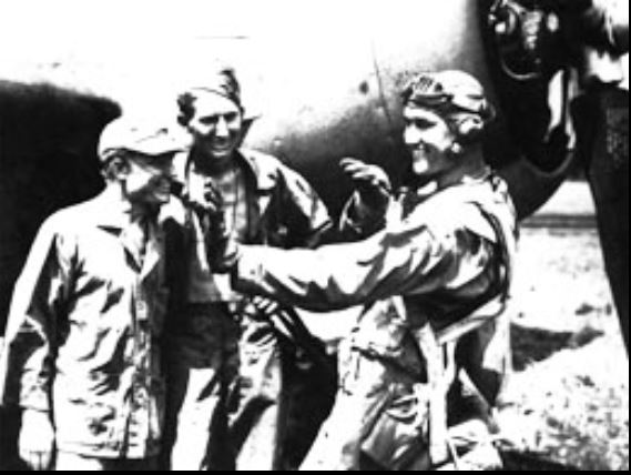 Bauer, at right, explains his technique to two ground crewmen.