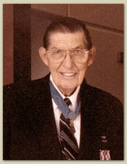 Color photo of Barfoot wearing his Medal of Honor and a blue suit. He is facing the camera and smiling.