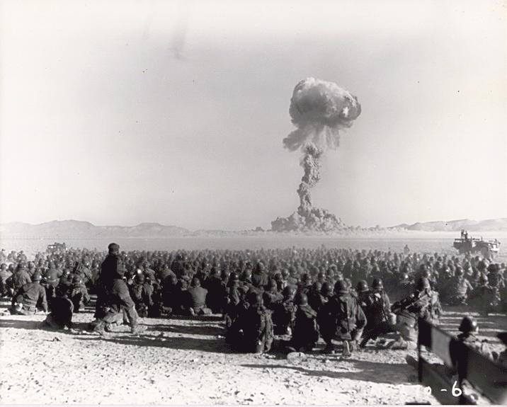 November 1951 nuclear test at Nevada Test Site. Test is shot “Dog” from Operation Buster, with a yield of 21 kilotons of TNT (88 TJ). It was the first U.S. nuclear field exercise conducted with live troops maneuvering on land. Troops shown are 6 mi (9.7 km) from the blast.