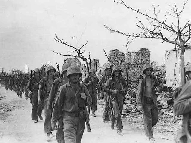 Marines march through Garapan, July 6, 1944.