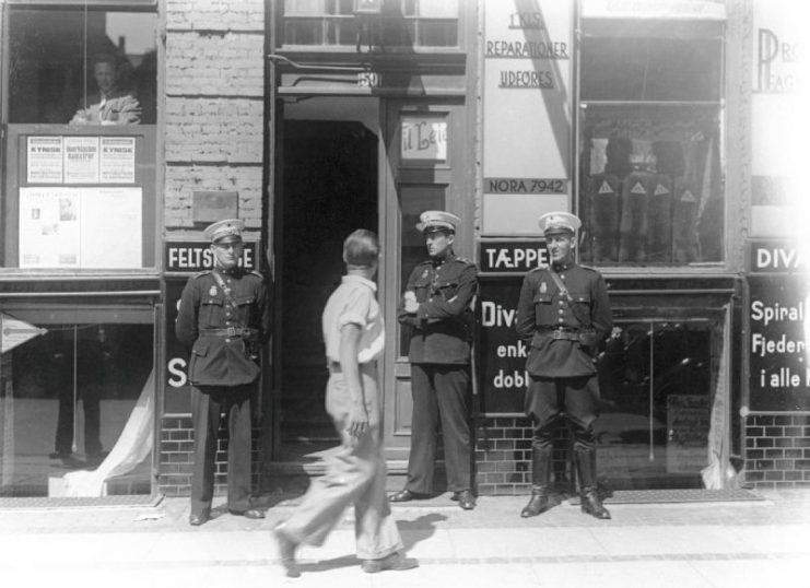 Danish Police officers stand in front of the Communist Party headquarters