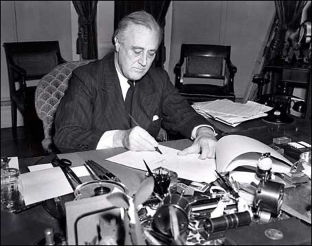 President Roosevelt signs the Lend-Lease bill to give aid to Britain and China (1941).