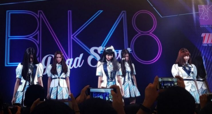Members Jennis, Nam-Neung, Maysa, Namhom, Kaimook, and Miori, clad in the first single outfit, perform at The Mall Bang Kapi in Bangkok on 23 July 2017.