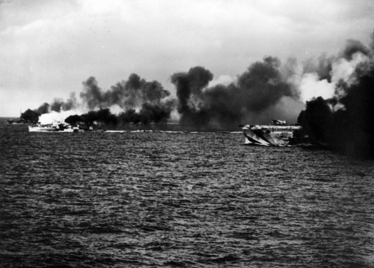 The U.S. Navy escort carrier USS Gambier Bay (CVE-73) and her escorts pictured amidst a smoke screen during a surface action off Samar during the Battle of Leyte Gulf.