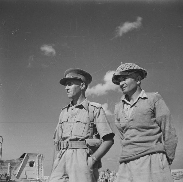 Lieutenant Colonel Howard Karl Kippenberger (later Sir), World War II Distinguished Service Order award, and Victoria Cross recipient Lieutenant Charles Hazlitt Upham (in covered helmet), Photo by http://beta.natlib.govt.nz/records/22720916CC BY-SA 3.0