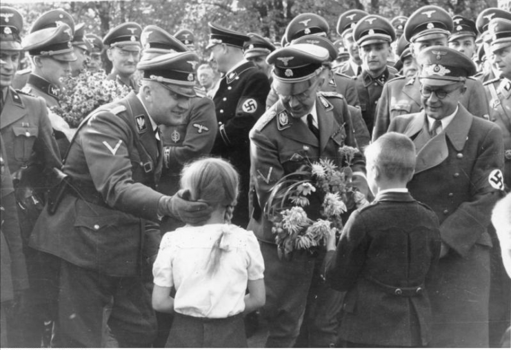 Two German children offer flowers to SS officer Wilhelm Koppe (left), chief Heinrich Himmler (centre) and Fritz Bracht, who was Gauleiter of Silesia at the time.Photo: Bundesarchiv, Bild 146-1969-052-27 / Unknown / CC-BY-SA 3.0