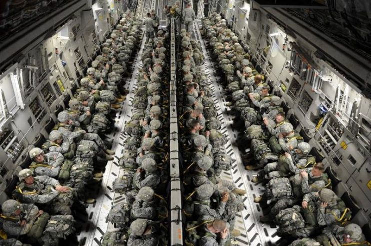U.S. Army paratroopers from the 82nd Airborne Division sit strapped into a U.S. C-17 Globemaster