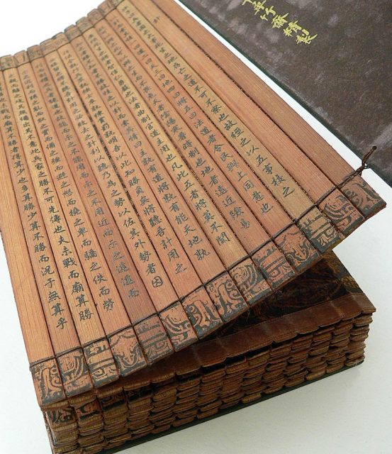 A Chinese bamboo book, open to display the binding and contents. This copy of The Art of War (on the cover, “孫子兵法”) by Sun Tzu is part of a collection at the University of California, Riverside. The cover also reads “乾隆御書”, meaning it was either commissioned or transcribed by the Qianlong Emperor.Photo:vlasta2 CC BY 2.0