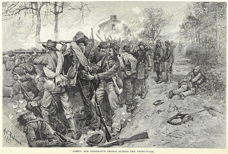 Confederate troops commanded by Generals Cobb and Kershaw fire at attacking Union soldiers from behind a stone wall during the Battle of Fredericksburg.