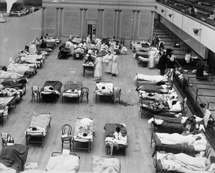 American Red Cross nurses tend to flu patients in temporary wards set up inside Oakland Municipal Auditorium, 1918.
