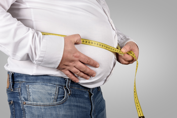 Overweight Man Measuring His Belly with tape measure