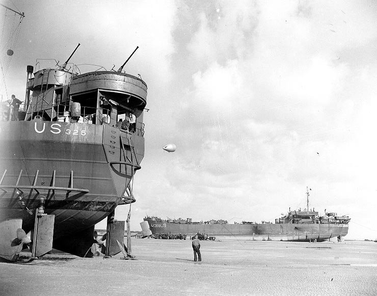 USS LST-325 (left) and USS LST-388 unloading while stranded at low tide during the Normandy Invasion in June 1944. Note: propellers, rudders, and other underwater details of these LSTs; 40 mm single guns; “Danforth” style kedge anchor at LST-325’s stern.