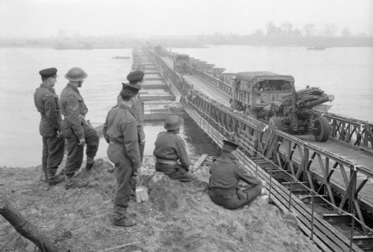 Royal Navy and Army personnel are watching guns being towed across the Rhine after completing building of the bridge.