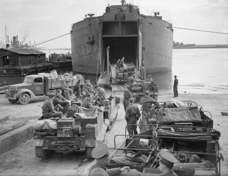 Bren Gun Carriers being loaded at Bone Harbour through the bow doors of HMS BACHAQUERO, an LST specially constructed for the task.