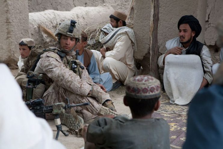 U.S. Marine Corps Sgt. Christan A. Marlow (left), with Bravo Company, 1st Battalion, 5th Marine Regiment, Regimental Combat Team 8, talks to Afghan nationals while conducting a reconnaissance patrol in Sangin, Afghanistan, on May 4, 2011.