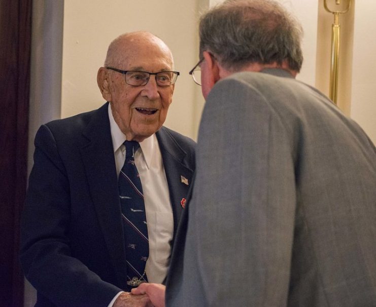 Retired Air Force Lt. Col. Dick Cole, one of four surviving members of Doolittle’s Raid, shakes hands with Robert Cressman, Naval History and Heritage Command historian and World War II expert, during a luncheon in honor of the raiders at the Army Navy Club in Washington