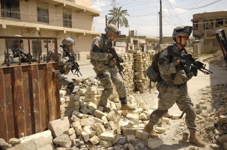 U.S. Army Soldiers make their way through rubble during a cordon and search in Old Baqubah, Iraq, April 3, 2007. The Soldiers are with the 5th Battalion, 20th Infantry Regiment, 3rd Stryker Brigade Combat Team, 2nd Infantry Division. (U.S. Air Force photo by Staff Sgt. Stacy L. Pearsall) CC BY 2.0