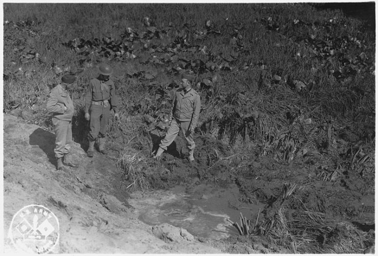 American servicemen inspecting a shell crater after the Japanese attack on Fort Stevens, Oregon