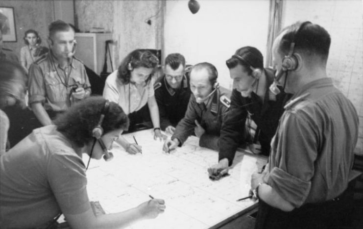 The radio control center for night fighters, with Jägerleitoffiziere and assistants plotting courses and directing the airborne fighters. Photo: Bundesarchiv, Bild 101I-680-8274A-15A / Faupel / CC-BY-SA 3.0