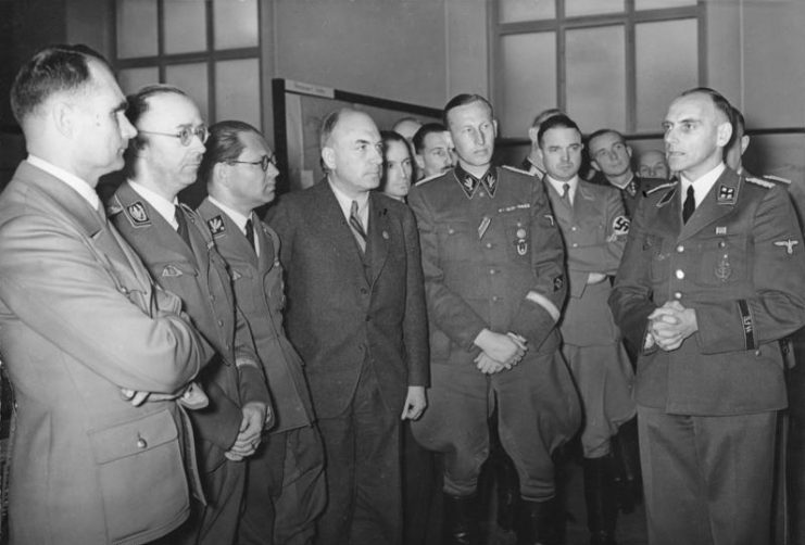Hess (first from left), Heinrich Himmler, Phillip Bouhler, Fritz Todt, Reinhard Heydrich, and others listening to Konrad Meyer at a Generalplan Ost exhibition, 20 March 1941. Photo: Bundesarchiv, Bild 183-B01718 / CC-BY-SA 3.0