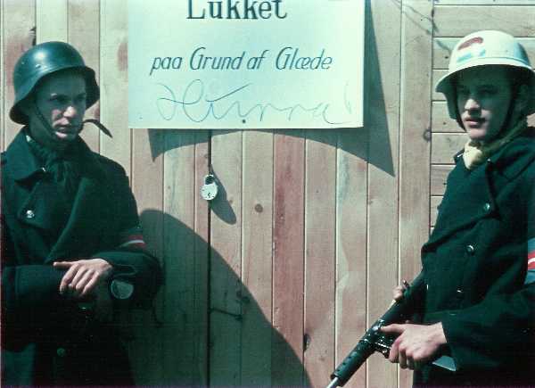 Two Danish resistance fighters are guarding a shop that is “closed due to happiness” after the liberation of Denmark by the British army on May 5 1945.